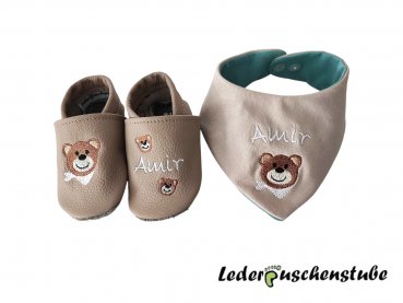 Lederpuschen beige mit rechts Stickerei Bär mit Tuch weiß und links Namen (weiß) mit 2 kleinen Bären + Wende-Halstuch: Vorderseite Jersey beige mit Namen (weiß), Rückseite Jersey (babyblau), Druckknopf transparent.